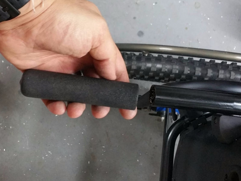 image of a hand removing standard sized wheelchair handle grip