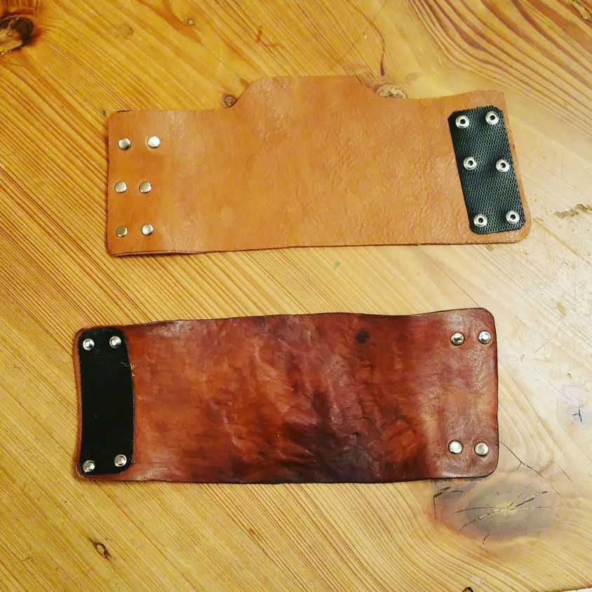 image of two leather bite guards, one with a wrist guard the other without